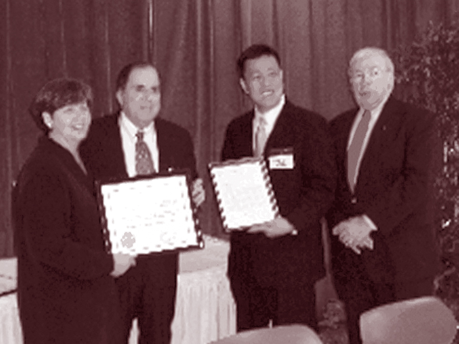 Photo of Assistant Attorney General Wan J. Kim presents an ADA Certification and a congratulatory letter to North Carolina Commissioner of Insurance James Long and staff members Laurel Wright and Jeffrey Kanner at February 9, 2006 ceremony in Cary, North Carolina, recognizing the ADA certification of the North Carolina Accessibility Code.
