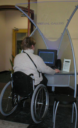 Photo:  Woman seated in a wheelchair operating a computer-based museum interactive
