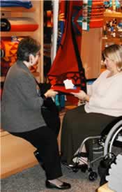 photograph of a woman in a wheelchair shopping with another woman