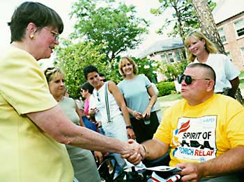 Janet Reno shakes hand with man using a wheelchair
