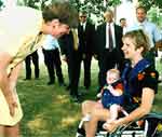 Janet Reno speaks with mother in wheelchair holding her baby 