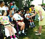 Janet Reno greets several children using wheelchairs
