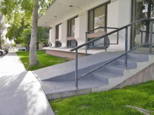 Too-steep entrance ramp without handrails and edge protection