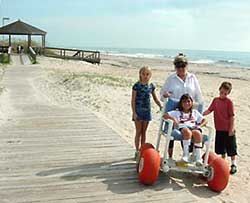 photo - family on beach with girl in beach wheelchair