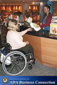 A picture of a female customer who uses a wheelchair at a store counter.