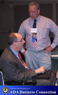Photo: A man is having a conversation with a man using a wheelchair; ADA Business Connection Logo