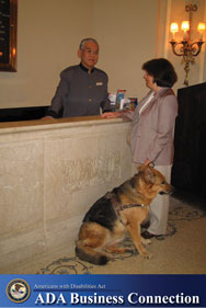 Photo: A woman with a service animal is at a hotel check-in counter; ADA Business Connection Logo