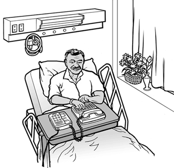 man using portable TTY from his hospital bed