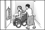 A woman using a wheelchair is trying on clothes in a dressing room. A friend is helping her.