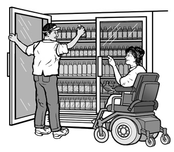 A convenience store employee reaches for a bottle of juice from the top rack of a drink cooler for a woman using a power wheelchair. 